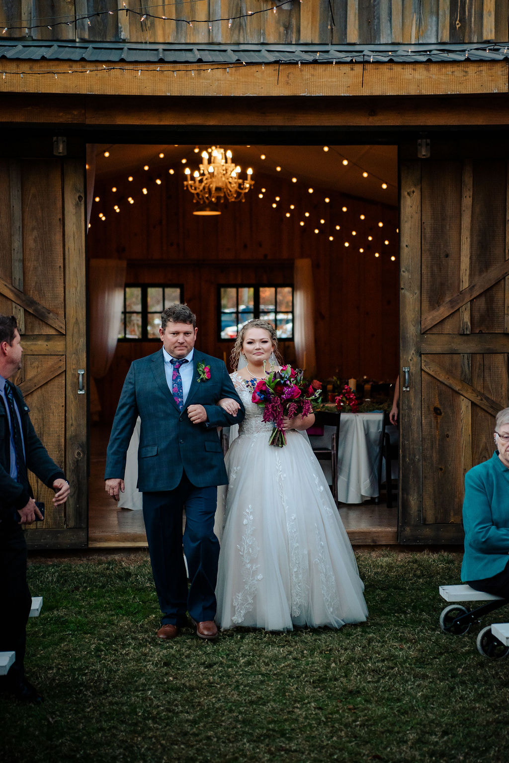 Bride and father walking down the aisle at barn venue