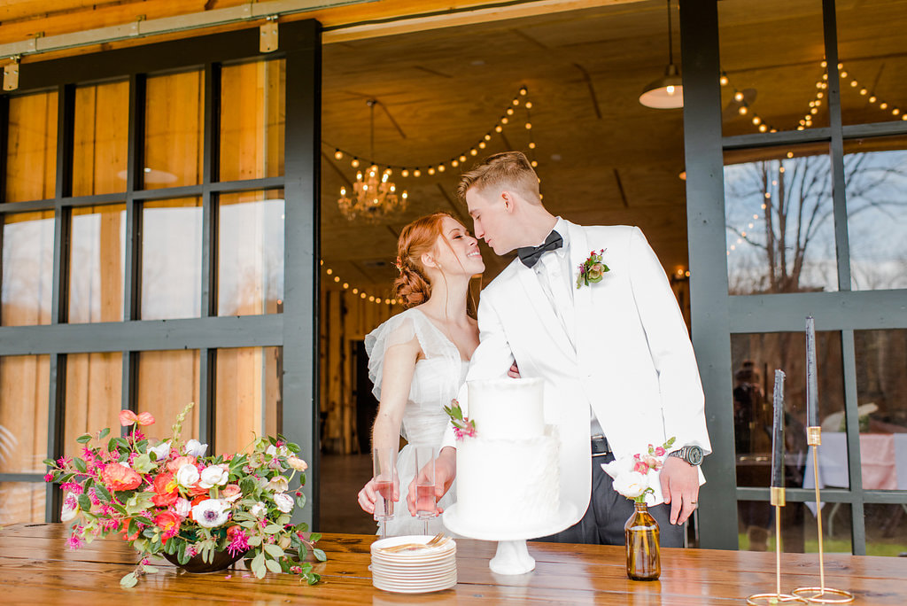 Bride and Groom in front of black glass doors with string lights