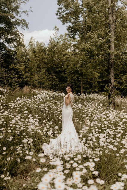 Bride in daisy field at North Georgia wedding venue
