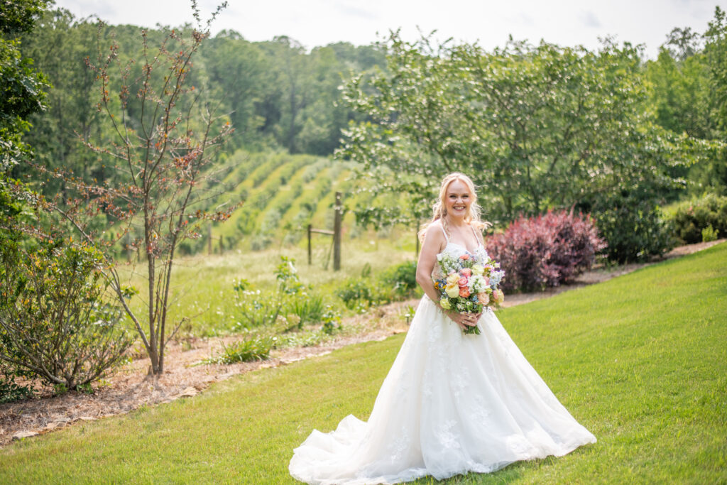 Bride in wedding dress in front of rolling farm view at spring wedding in North Georgia